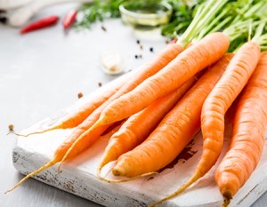 Carrots laying on a chopping board. 